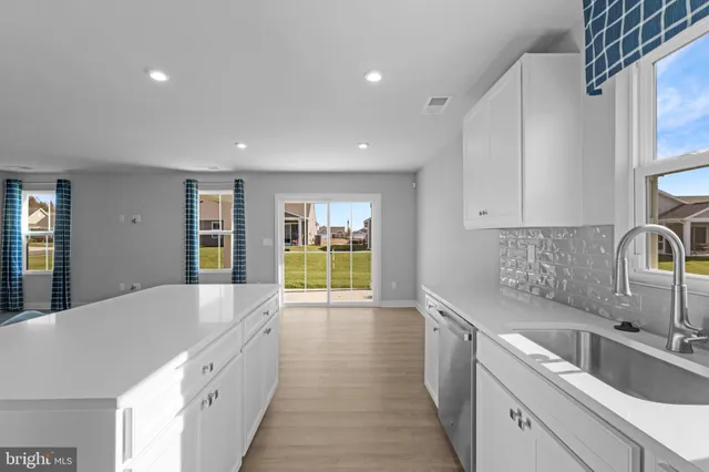 a large kitchen with stainless steel appliances granite countertop a sink and dishwasher a stove with wooden floors