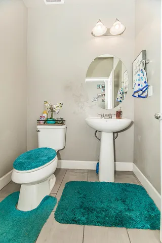 a bathroom with a sink mirror and toilet