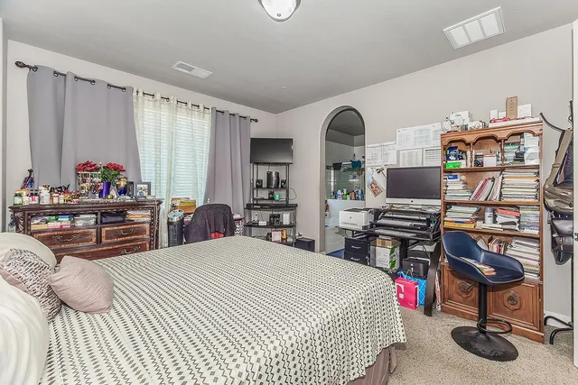 a bedroom with bed and a chandelier