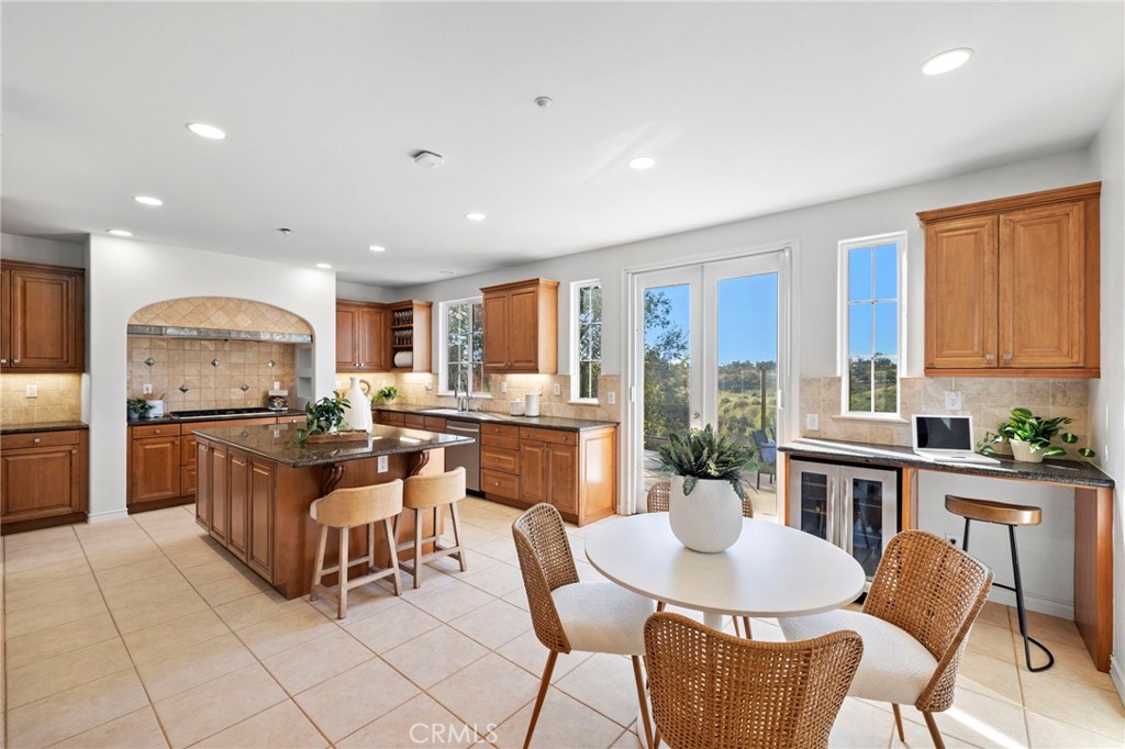 15 Mason Lane Ladera Ranch, CA 92694 - Photo 11 of 40 a kitchen with stainless steel appliances granite countertop a stove top oven a sink dishwasher a dining table and chairs with wooden floor