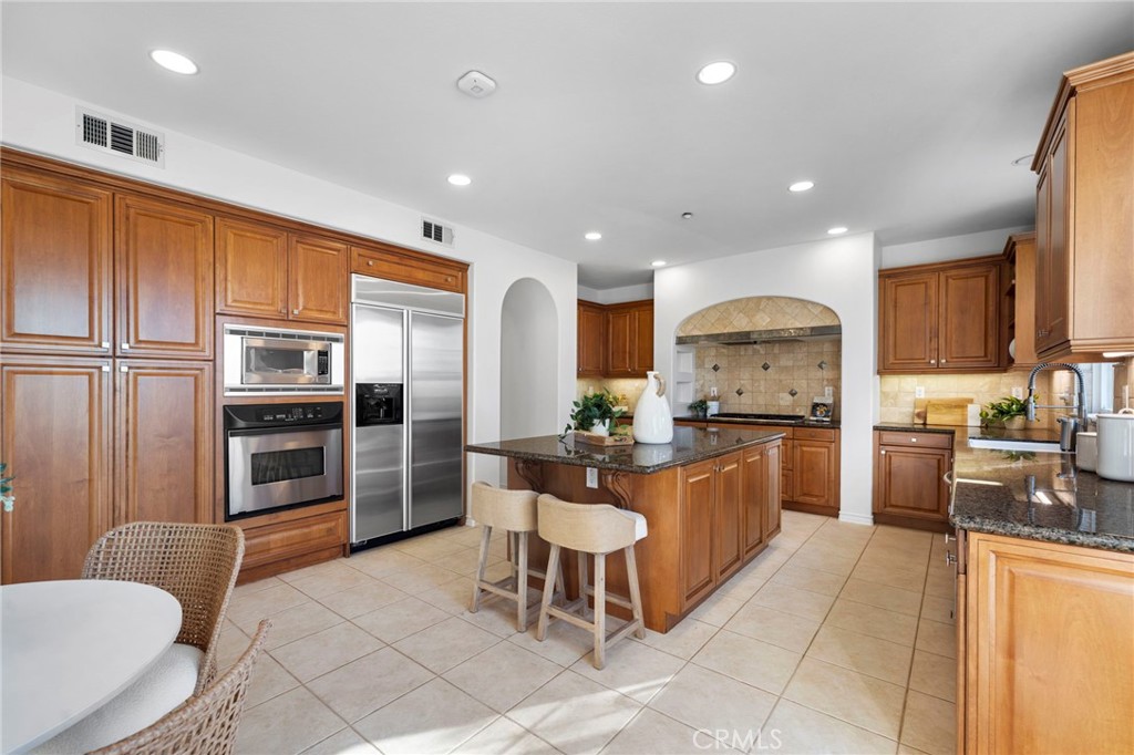 15 Mason Lane Ladera Ranch, CA 92694 - Photo 14 of 40 a kitchen with stainless steel appliances a refrigerator a stove top oven and a sink