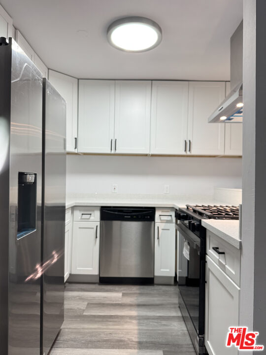 a kitchen with granite countertop white cabinets and stainless steel appliances