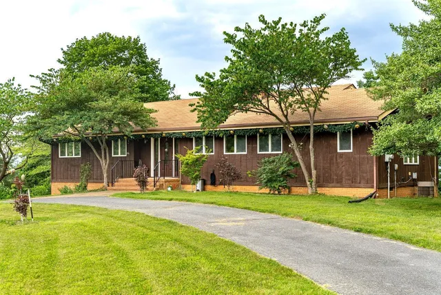 a front view of a house with a yard and trees