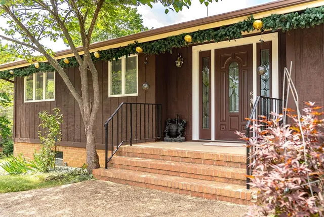 a view of a house with a large windows and plants