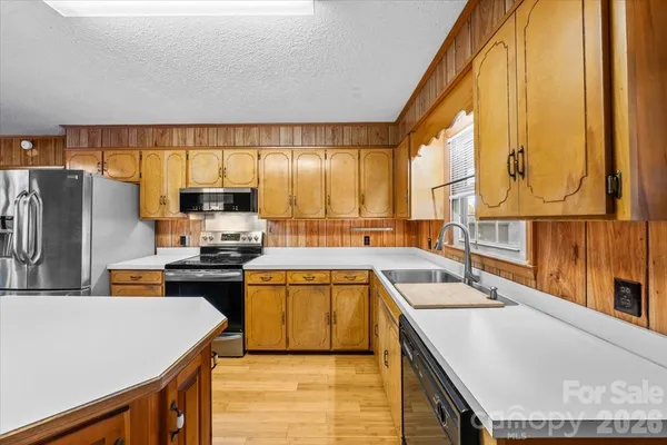 a kitchen with stainless steel appliances granite countertop sink stove top oven and cabinets