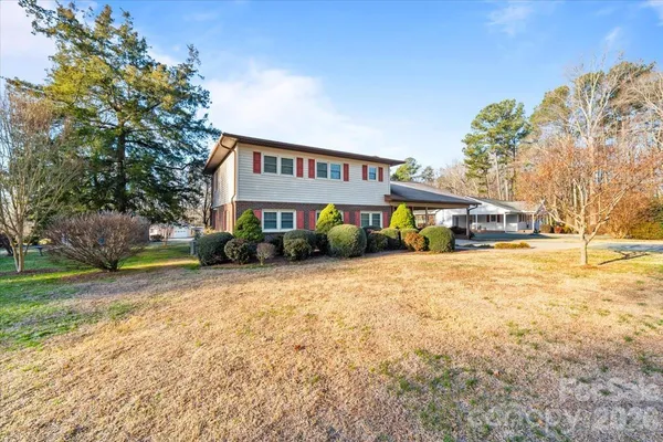 a front view of house with yard and trees in the background