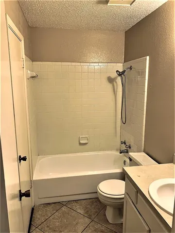 a bathroom with a toilet sink vanity tub and shower