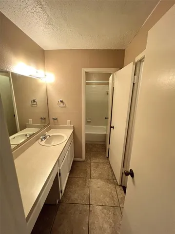 a bathroom with a granite countertop sink a mirror and a shower