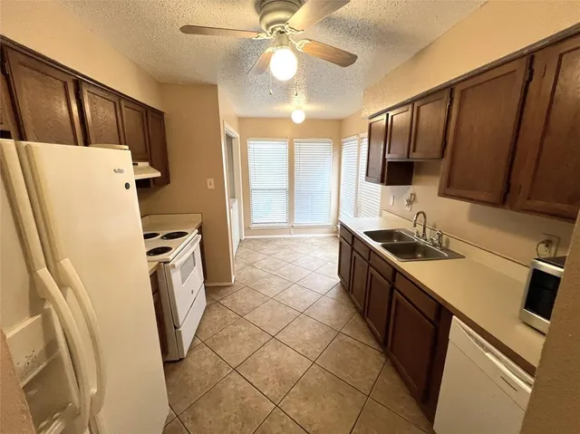 a kitchen with a sink a refrigerator and cabinets