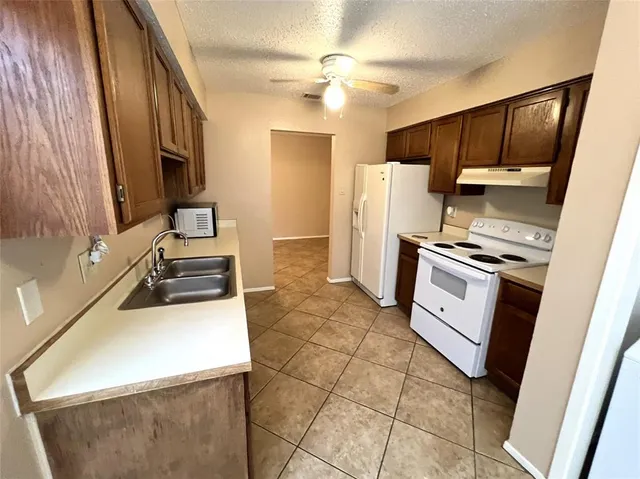 a kitchen with a stove a refrigerator and a sink
