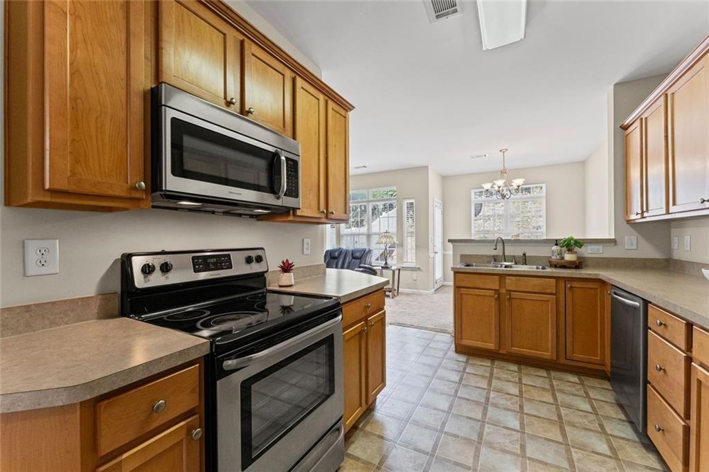 2743 Pierce Brennen Court Northeast Lawrenceville, GA 30043 - Photo 11 of 31 a kitchen with stainless steel appliances a stove microwave and sink
