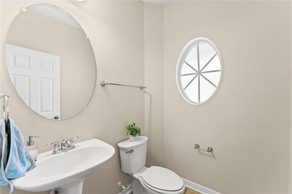 2743 Pierce Brennen Court Northeast Lawrenceville, GA 30043 - Photo 15 of 31 a bathroom with a sink a mirror a toilet and a window