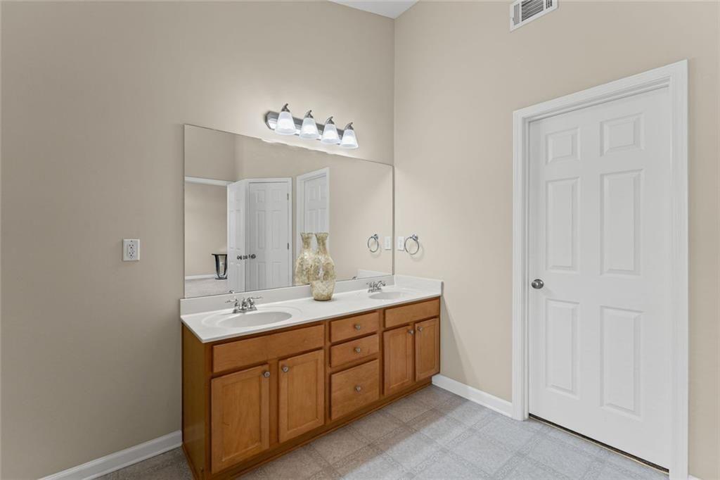 2743 Pierce Brennen Court Northeast Lawrenceville, GA 30043 - Photo 19 of 31 a spacious bathroom with a double vanity sink and a mirror