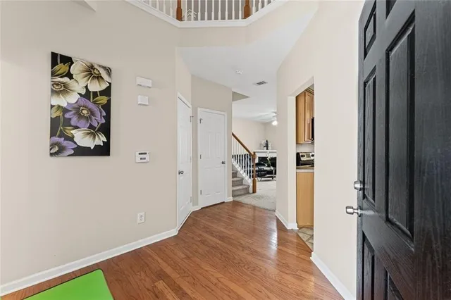 a view of a hallway with wooden floor and closet