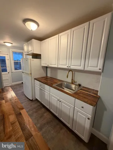 a kitchen with a sink a refrigerator and cabinets