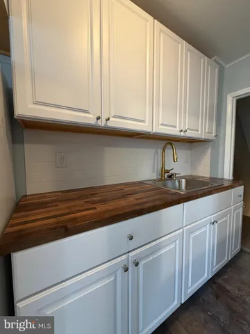 a kitchen with granite countertop white cabinets and a sink