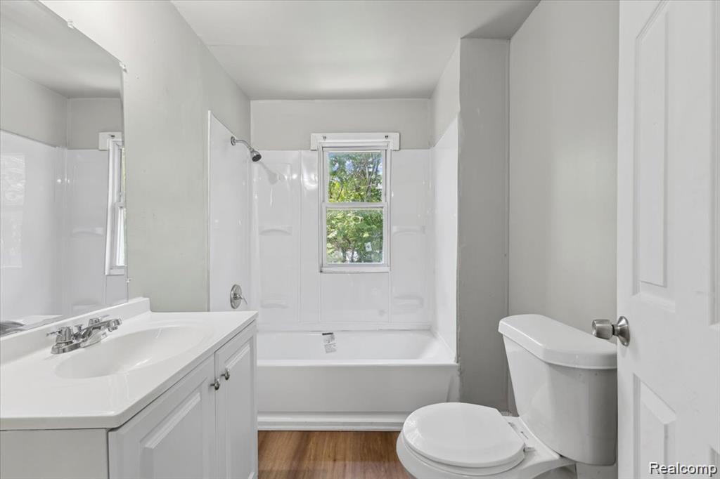 3140 Moore Street Inkster, MI 48141 - Photo 8 of 18 Bathroom with wood-finish flooring, a white vanity with an integrated sink, a chrome faucet, and a large mirror