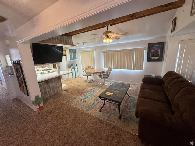 1225 North Dixie Downs Road, Unit 100 St. George, UT 84770 - Photo 3 of 22 Living area featuring wood-finish ceiling beams, ceiling fan light fixture, and vertical blinds