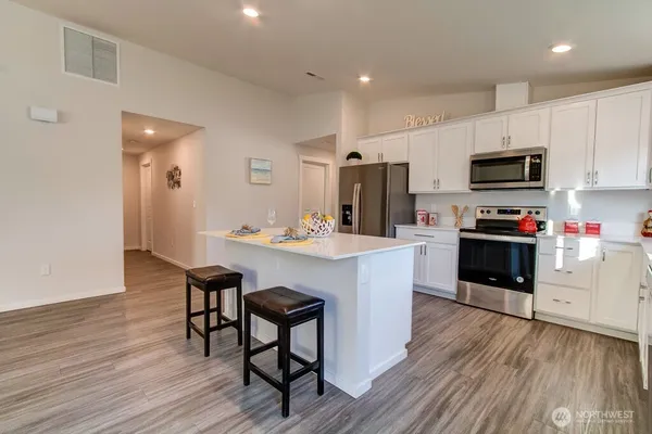 a kitchen with stainless steel appliances kitchen island granite countertop a stove a sink and a microwave