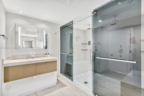 a bathroom with a tub sink shower and mirror