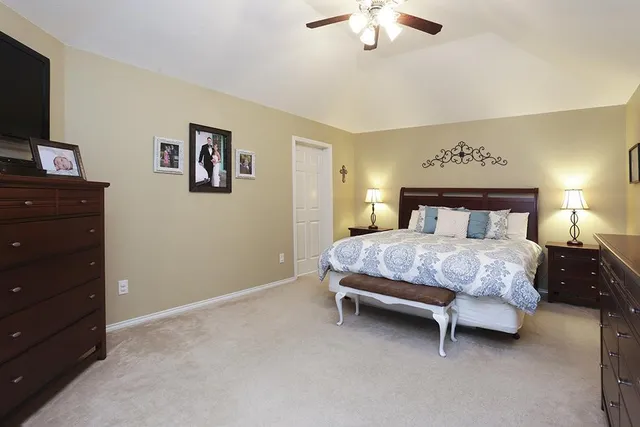 a bedroom with a bed and a flat tv screen on dresser