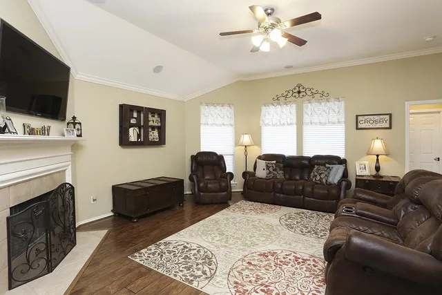 a living room with furniture a flat screen tv and a fireplace
