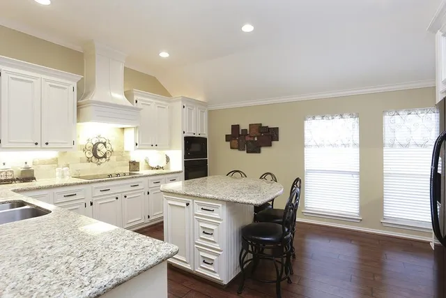 a kitchen with granite countertop white cabinets and appliances