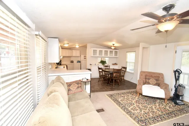 a large white kitchen with a stove a sink dishwasher and a refrigerator with wooden floor