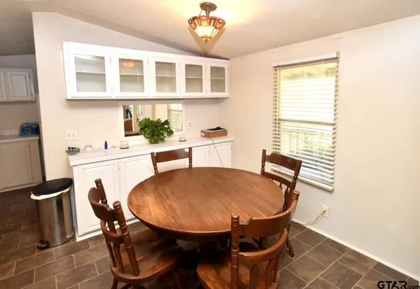 a kitchen with white cabinets and appliances