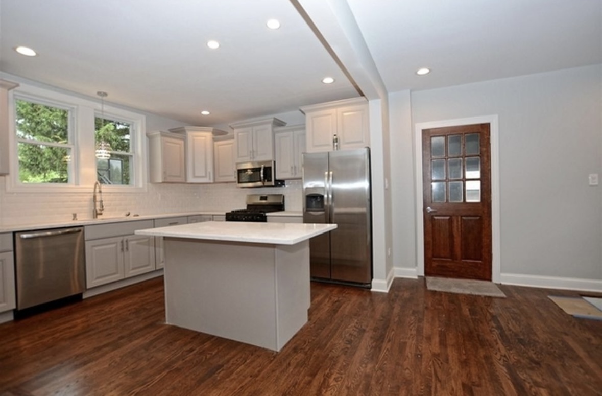 Undisclosed Address Chicago, IL 60628 - Photo 11 of 27 a kitchen with kitchen island granite countertop a sink cabinets and wooden floor