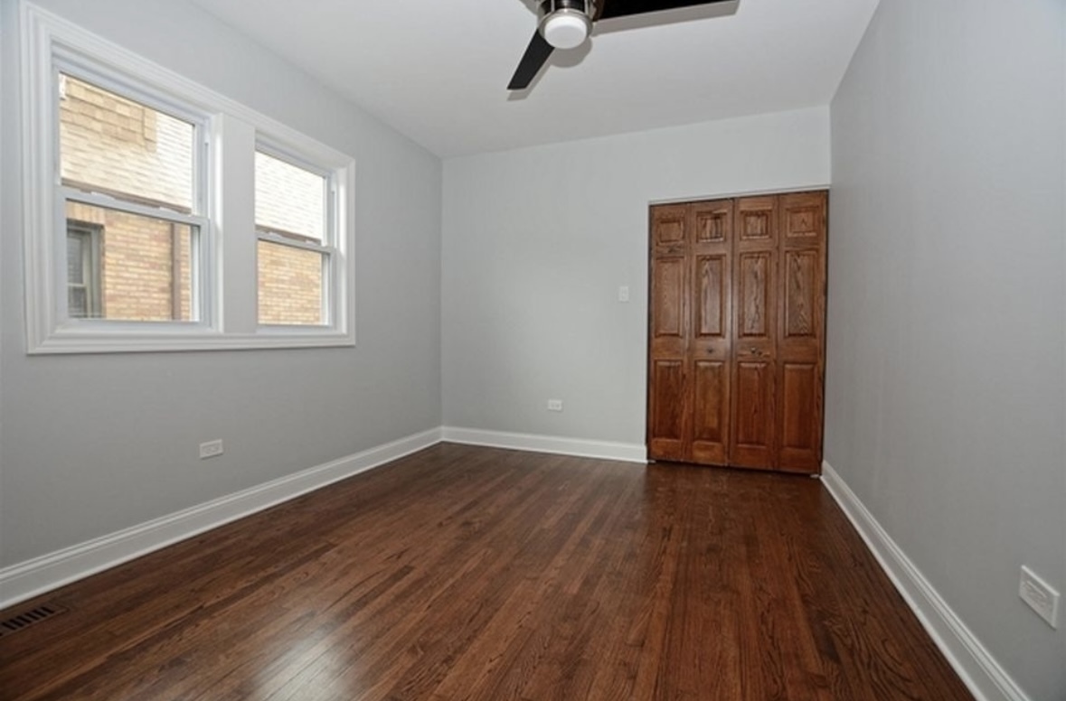 Undisclosed Address Chicago, IL 60628 - Photo 17 of 27 an empty room with wooden floor closet and windows