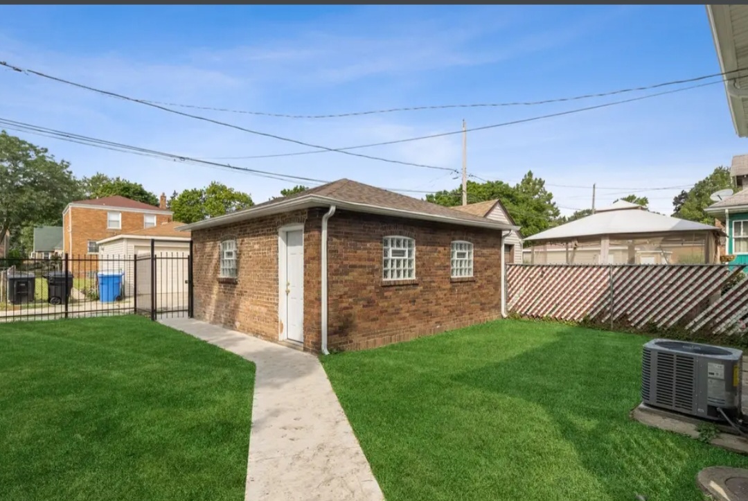 Undisclosed Address Chicago, IL 60628 - Photo 5 of 27 a front view of a house with a yard