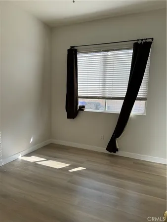 a view of a room with wooden floor and a window