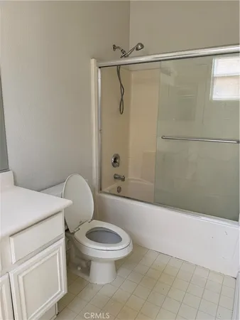 a white toilet and tub sitting next to a bathroom sink