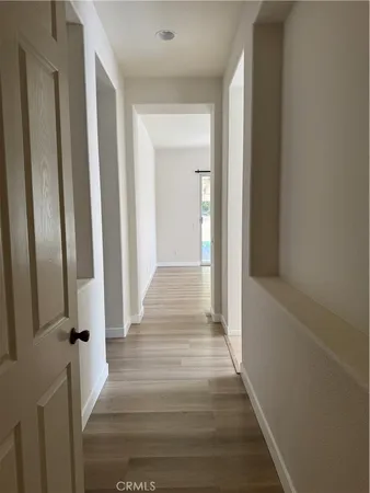 a view of a hallway with wooden floor and staircase
