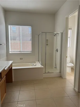 a bathroom with a tub shower and toilet