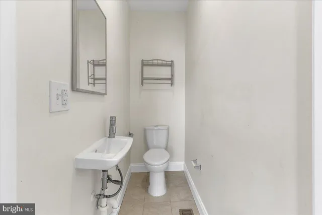 a bathroom with a sink a toilet and a mirror