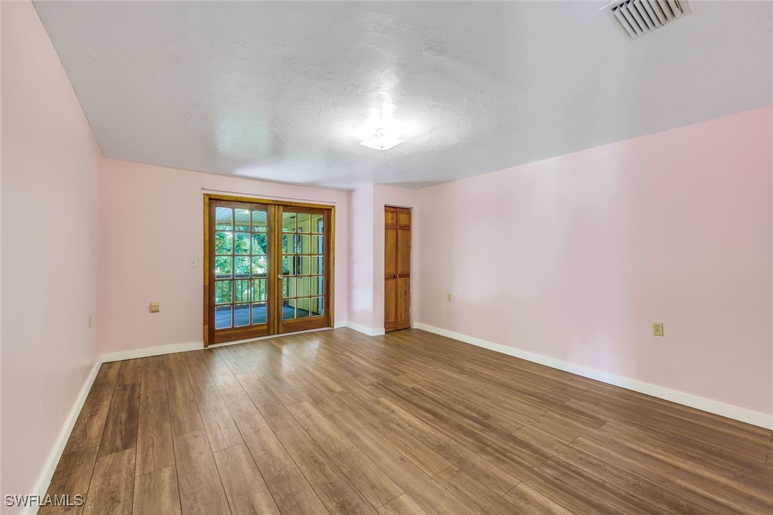 18191 Slater Road North Fort Myers, FL 33917 - Photo 21 of 34 a view of an empty room with wooden floor and a window