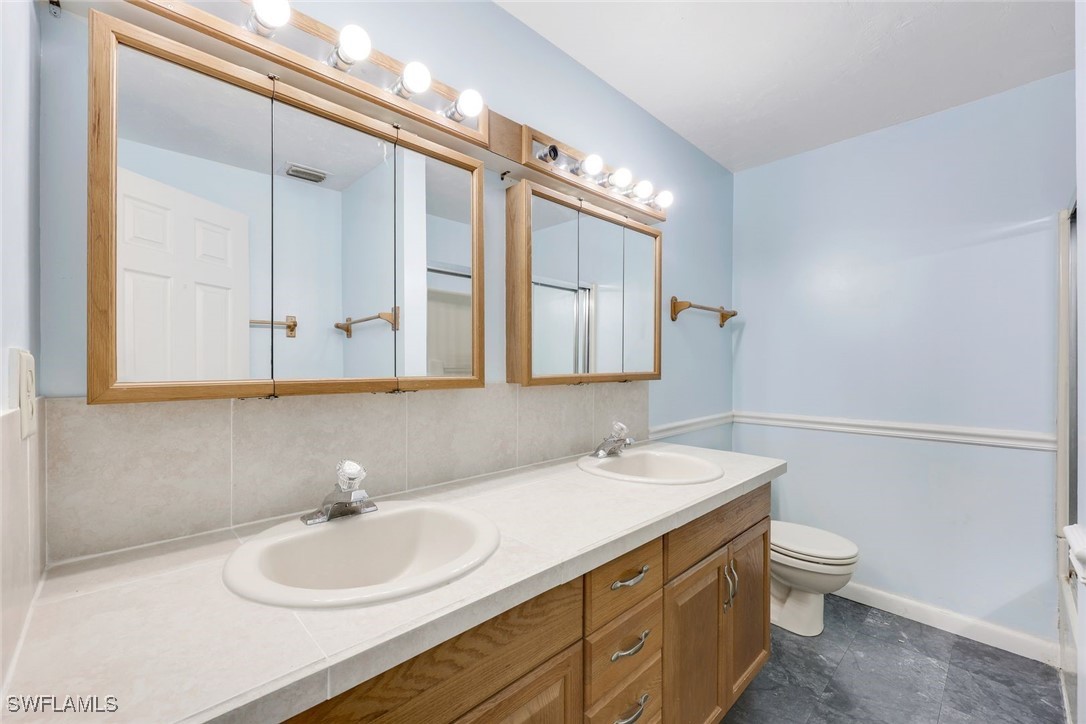 18191 Slater Road North Fort Myers, FL 33917 - Photo 25 of 34 a bathroom with a double vanity sink and a mirror