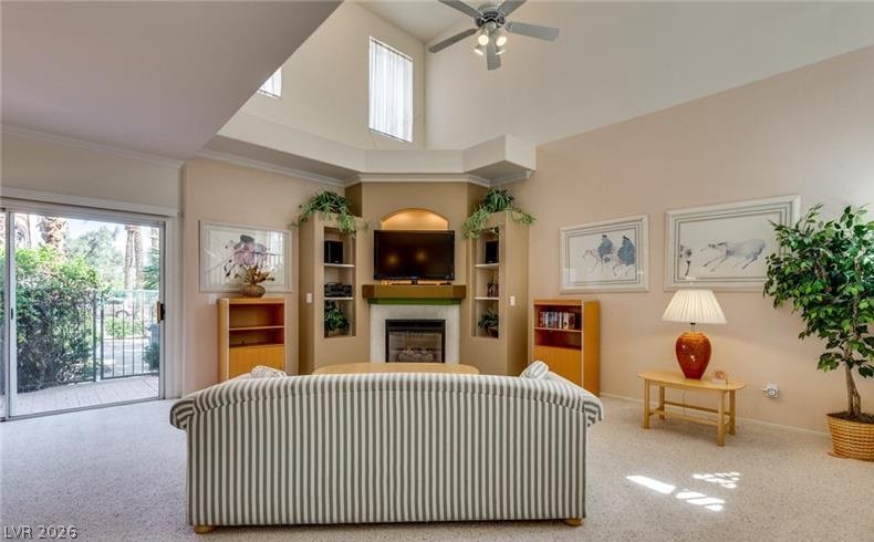 5272 Island Chain Road Las Vegas, NV 89118 - Photo 29 of 31 A living area with soaring vaulted ceilings and a corner fireplace, opening onto an enclosed outdoor space.