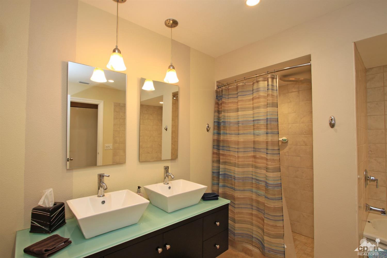 72350 Rodeo Way Rancho Mirage, CA 92270 - Photo 21 of 44 a bathroom with a sink a light fixture and a glass door shower
