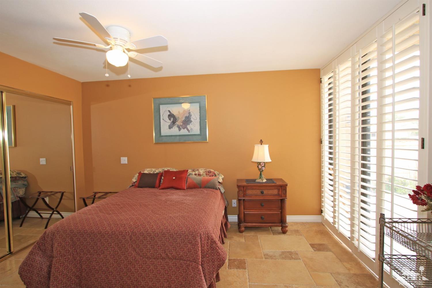72350 Rodeo Way Rancho Mirage, CA 92270 - Photo 22 of 44 a bedroom with a bed and a chandelier