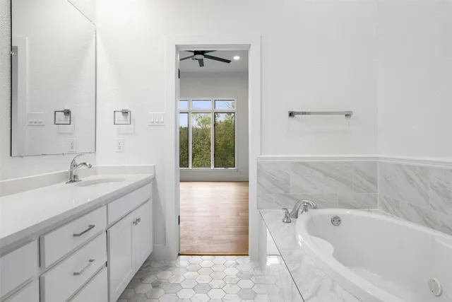a bathroom with a tub sink and mirror