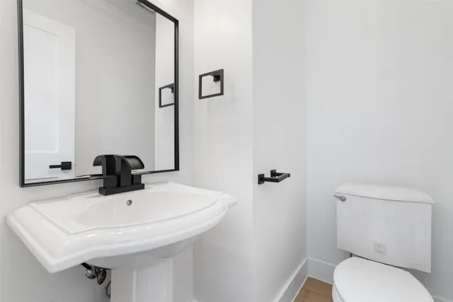 a bathroom with a sink a toilet and mirror