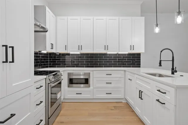a kitchen with white cabinets and sink