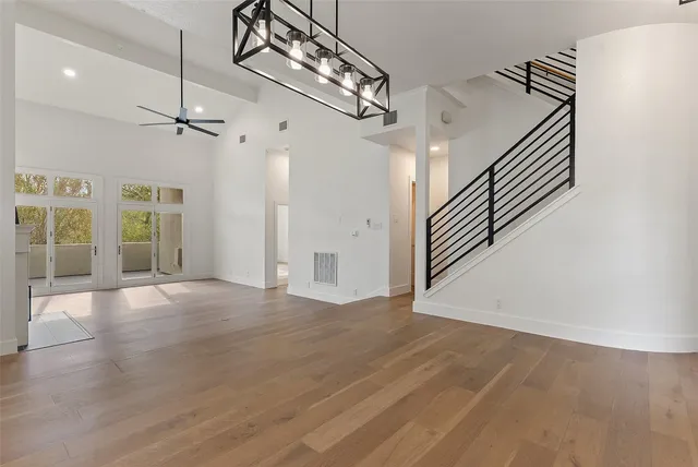 en empty room with wooden floor and ceiling fan
