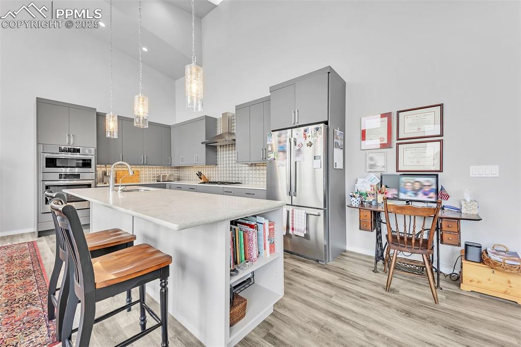 414 Eclipse Drive Colorado Springs, CO 80905 - Photo 14 of 50 Kitchen with stainless steel appliances, a sink, open shelves, hanging light fixtures, and gray cabinets