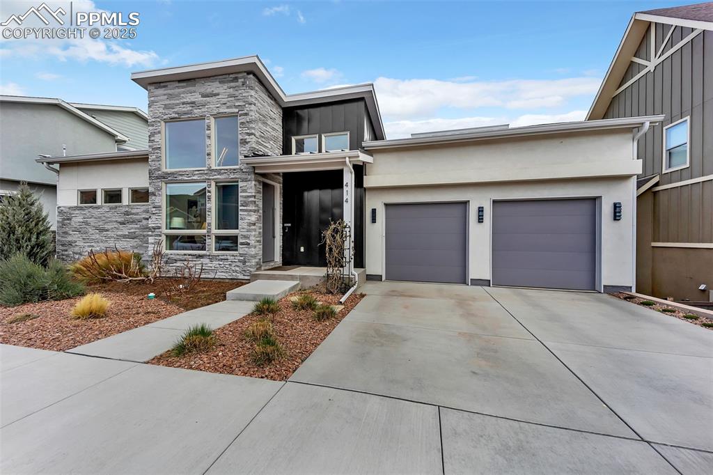 414 Eclipse Drive Colorado Springs, CO 80905 - Photo 2 of 50 View of front facade with concrete driveway, stucco siding, an attached garage, stone siding, and board and batten siding
