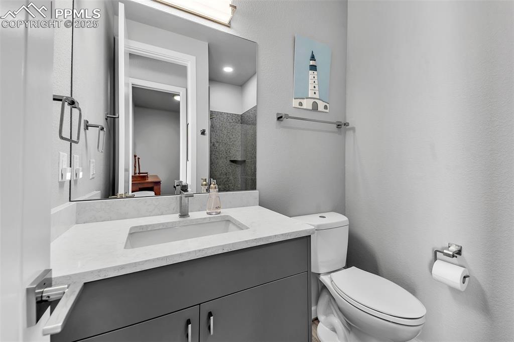 414 Eclipse Drive Colorado Springs, CO 80905 - Photo 37 of 50 Full bathroom featuring toilet, tiled shower, and vanity