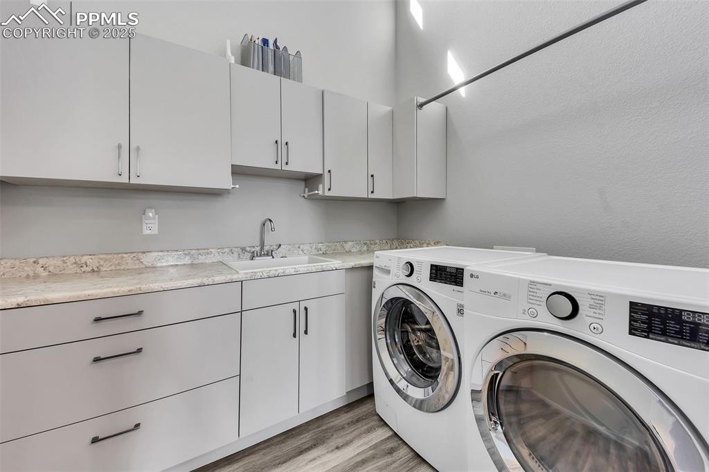 414 Eclipse Drive Colorado Springs, CO 80905 - Photo 42 of 50 Laundry area featuring light wood finished floors, a sink, laundry area, and separate washer and dryer